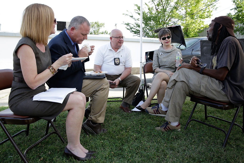 Police Chief Ken Burton sits among others and talks during a barbecue
